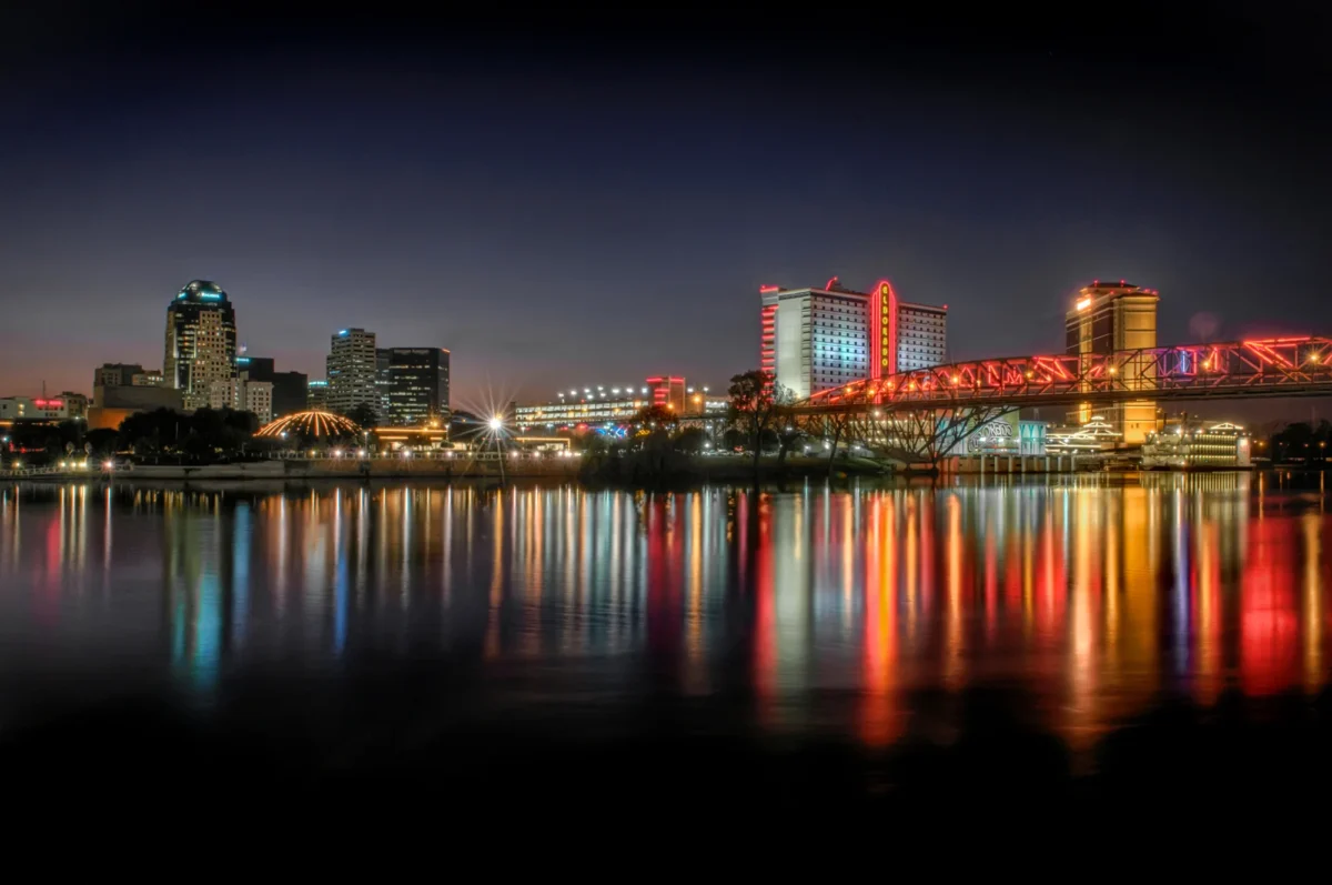 Nighttime photo of Shreveport and the Texas Street bridge with reflections in the water